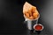 BBQ cheese fried stripes in a metal bucket onblack background with sauce fryed