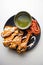 BBq chicken Tangri or tangdi with chili sauce served in a dish isolated on grey background top view of bangladesh food