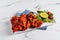 BBQ Chicken Tikka boti with lime in a dish isolated on napkin side view on grey background