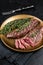 BBQ grilled Bavette Bavet beef meat steak with herbs on a plate. Black background. Top view
