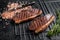 BBQ Grilled cap rump or Top sirloin beef steak, fried meat on grill. Black background. Top view