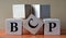 BCP - acronym on large wooden cubes on light brown background