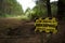 Be aware beekeeping activity ahead yellow and black sign warning sign beside an unpaved road track in Riverhead Forest, Kumeu, New