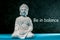 Be in balance - inspiration phrase with little white meditate buddha. Zen, yoga and life concept