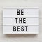 `Be the best` words on a light box on a white wooden background. Flat lay, overhead, top view. Close-up