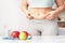 Be on Diet. Chubby girl standing holding fat fold near kitchen table with tape measure and fruits close-up blurred