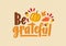 Be Grateful phrase or message handwritten with calligraphic script and decorated by squash, fallen autumn foliage and