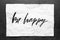 Be happy. Lettering on crumpled white paper. Handwritten text. Inspirational quotes.