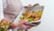 Be Healthy close-up of beige baking sheet potato baked salad woman with large breasts holds and turns baking sheet holds