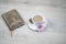 Be inspire notebook with cup of coffee and purple daisy flower and cookies on white wood table background.