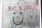 `Be kind` with a smiley face and love heart drawn into white wash on a empty shop window to spread some love and positivity duri