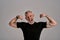 Be more, do more. Angry middle aged muscular man in black t shirt shouting at camera, showing his biceps while posing in