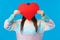 Be my valentine. Cute romantic shy girl in sweater hiding head behind red big heart sign, express love, confessing to