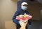 Be my Valentine: a delivery man delivers flowers in a face mask and gloves