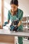 Be patient a little. Vertical photo of professional female veterinarian bandaging a paw of a big black cat lying on the