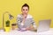 Be quiet. Serious woman in striped shirt sitting at workplace showing silence sign.