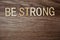 Be Strong alphabet letters on wooden background business concept