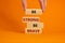 Be strong be brave symbol. Wooden blocks with words `be strong be brave`. Beautiful orange background. Businessman hand. Copy