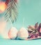 Beach accessories : straw hat, palm leaves and coconut cocktail on blue turquoise background, front view.