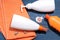 Beach accessories. Various creams on an orange towel on a blue wooden background. Top view