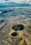 Beach with aged old rocky surface, soft waves and clouds