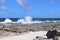 Beach area with a rocky shoreline and waves breaking