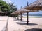 Beach area on the seashore near a quarantined hotel. beach umbrellas made of wood and palm leaves. everything around is covered wi