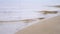 Beach background with sea wave. Stock footage. Calm water on the sandy beach