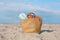 Beach bag with towel, book and sunscreen on sand