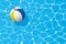 Beach ball floating in a swimming pool. Summer background.