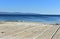 Beach in a bay with wooden boardwalk. Blue sea and clear sky, sunny day. Galicia, Spain.