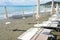 Beach beds and beach umbrellas empty by the sea