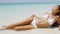 Beach bikini body - sexy slim woman on vacation sunbathing tanning in water
