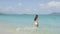 Beach bikini woman walking into ocean swimming