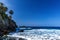 Beach with black volcanic sand, green palm trees on the slope, dangerous waves, Atlantic Ocean, Castro Beach