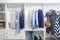 Beach blue clothes hanging in white wardrobe in home