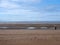 Beach at blundell flats in southport with water on the beach and the wind turbines at burbo bank visible in the distance