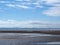 Beach at blundell sands near sefton, southport with water from the incoming tide reflecting clouds and sky