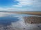 Beach at blundell sands near southport with water from the incoming tide reflecting clouds and sky