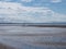 Beach at blundell sands near southport with water from the incoming tide reflecting and liverpool city visible in the distance