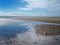 Beach at blundell sands in sefton near near southport with water from the incoming tide reflecting clouds and sky