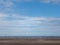 Beach at blundell sands in southport with waves breaking on the beach and the wind turbines at burbo bank visible in the
