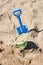 Beach bucket and a beach shovel stuck in the sand by a child