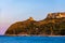 Beach of Cagliari Poetto Sella del Diavolo with Torre del Poetto tower and boats at sunset, Sardinia, Italy