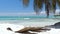 Beach calm scene with sunbeds under coconut palms close to Caribbean sea