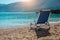 Beach chair from back on tranquil pebble beach. Amazing view to impressive rocks in the water. Serenity and isolation on