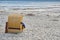 Beach chair with crutches leaning against it in the sand at the sea, summer vacation of people with special needs, copy space