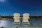 Beach chairs on night beach with stars sky