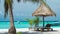 Beach chairs, umbrella and palms on the beach. Tourist arriving with an speedboat. Koh Lipe Island, Thailand, Asia