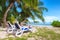 Beach chairs under a palm tree on tropical beach at Seychelles.